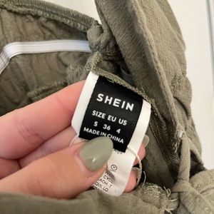 Green romper. Three ties in the front. Low cut.